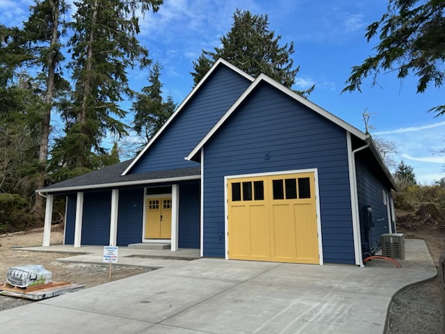 Finished navy custom home with yellow front doors and garage