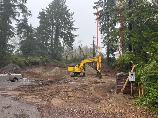 Cleared and excavated building lot with an excavator on site